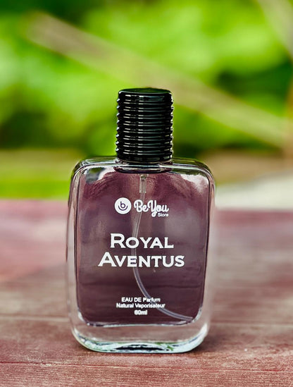 BeYou Royal Aventus perfume bottle on a wooden surface with a blurred green background